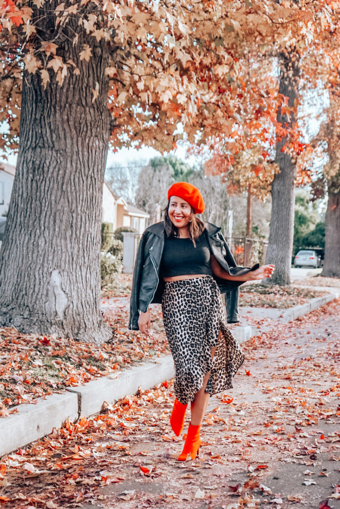 Woman dancing in red beret and leopard print skirt with red ankle boots.