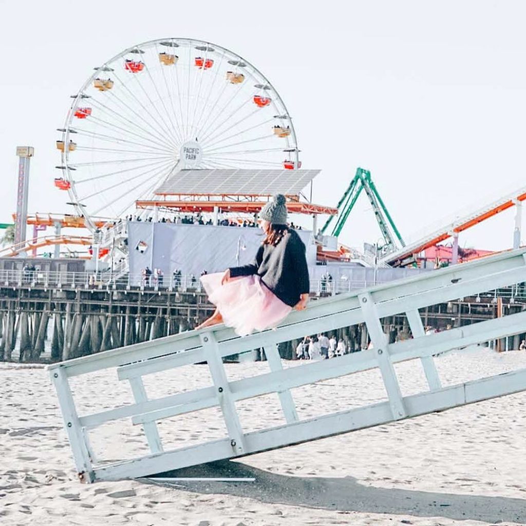 Woman sitting on a lifeguard tower in a tutu in Santa Monica Pier.