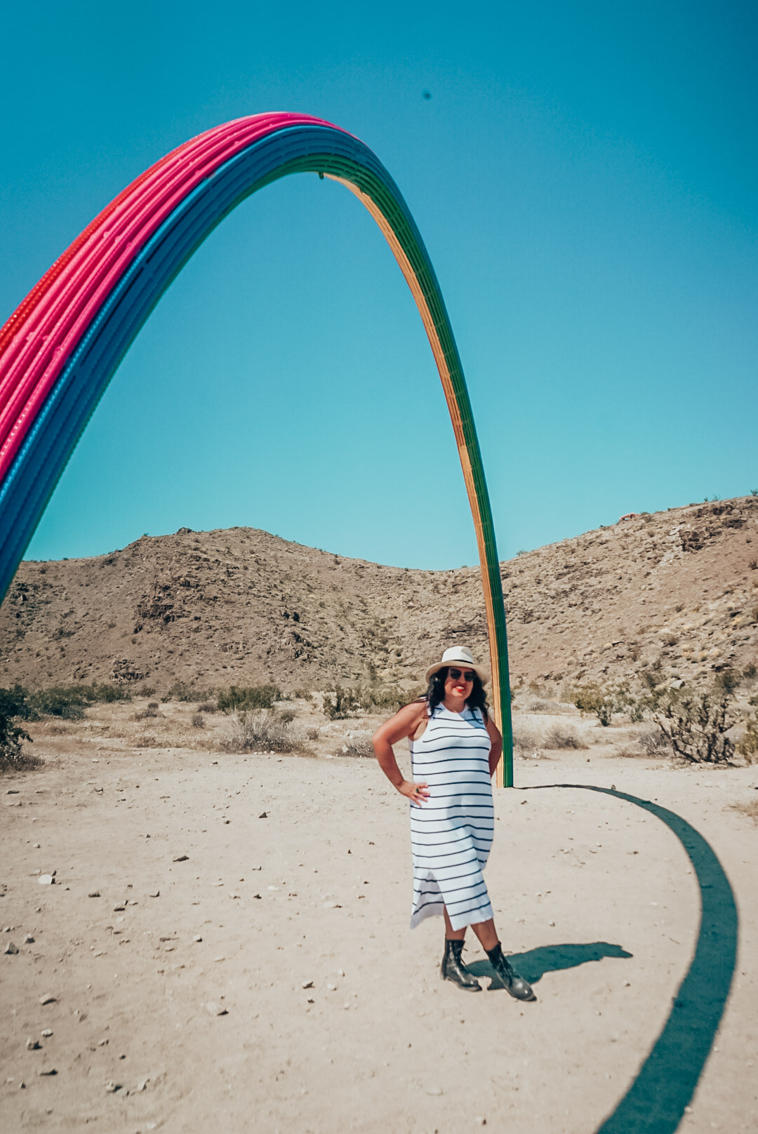 Woman under Lover's Rainbow sculpture in Rancho Mirage, Desert X. 