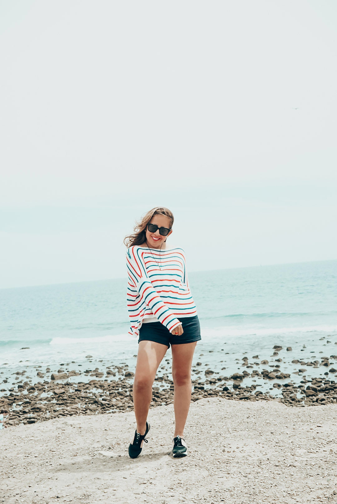 Girl in red white and blue knit sweater at the beach. 