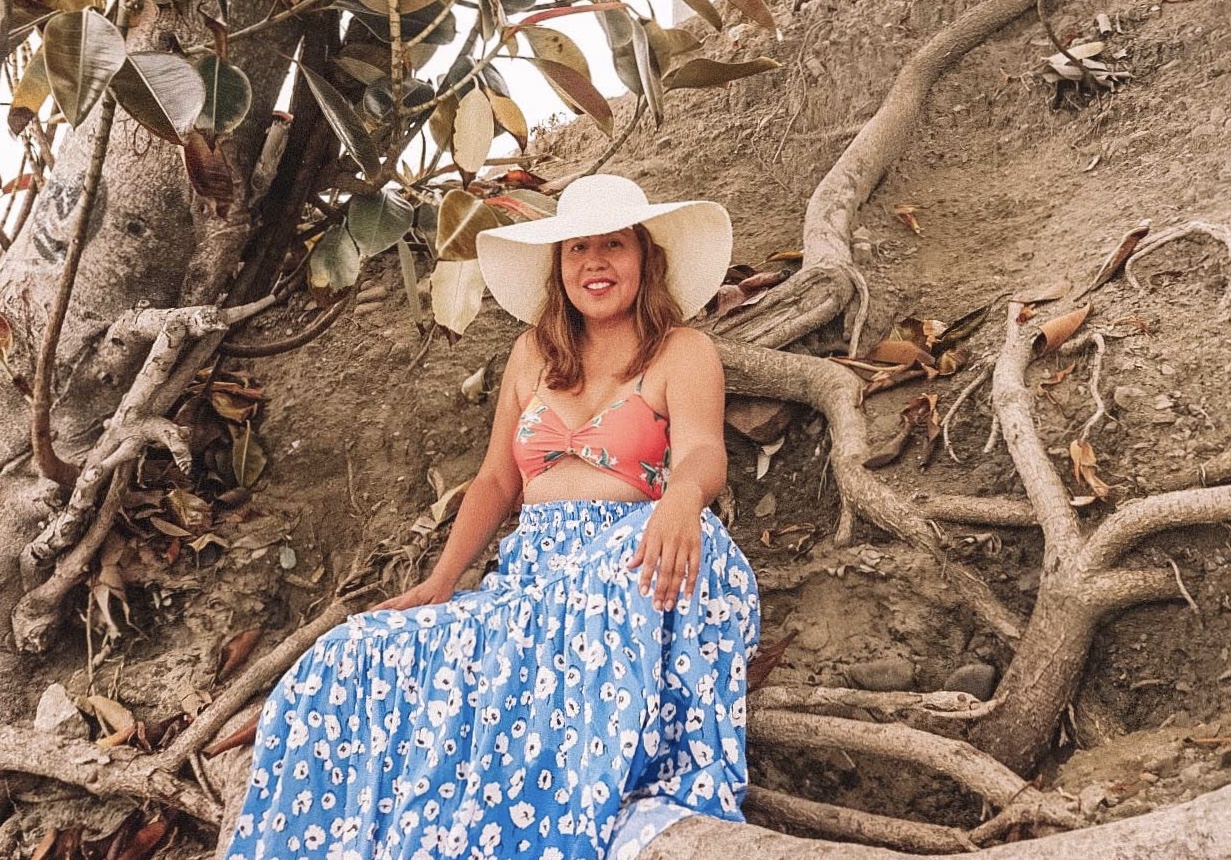 Cutout bathing suit top and long tiered skirt are styled perfectly with a floppy hat. 