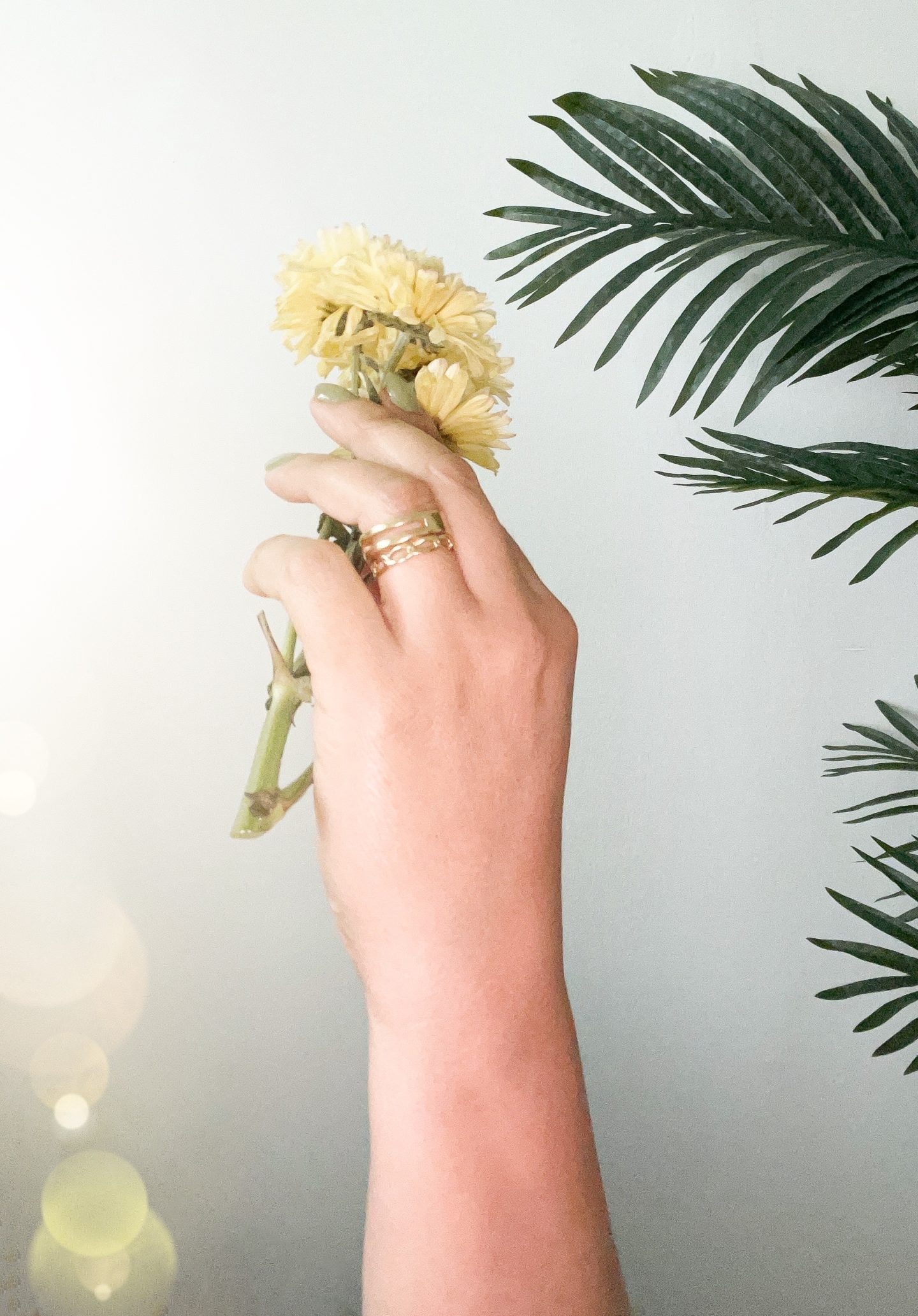 Hand wearing stack of gold rings.